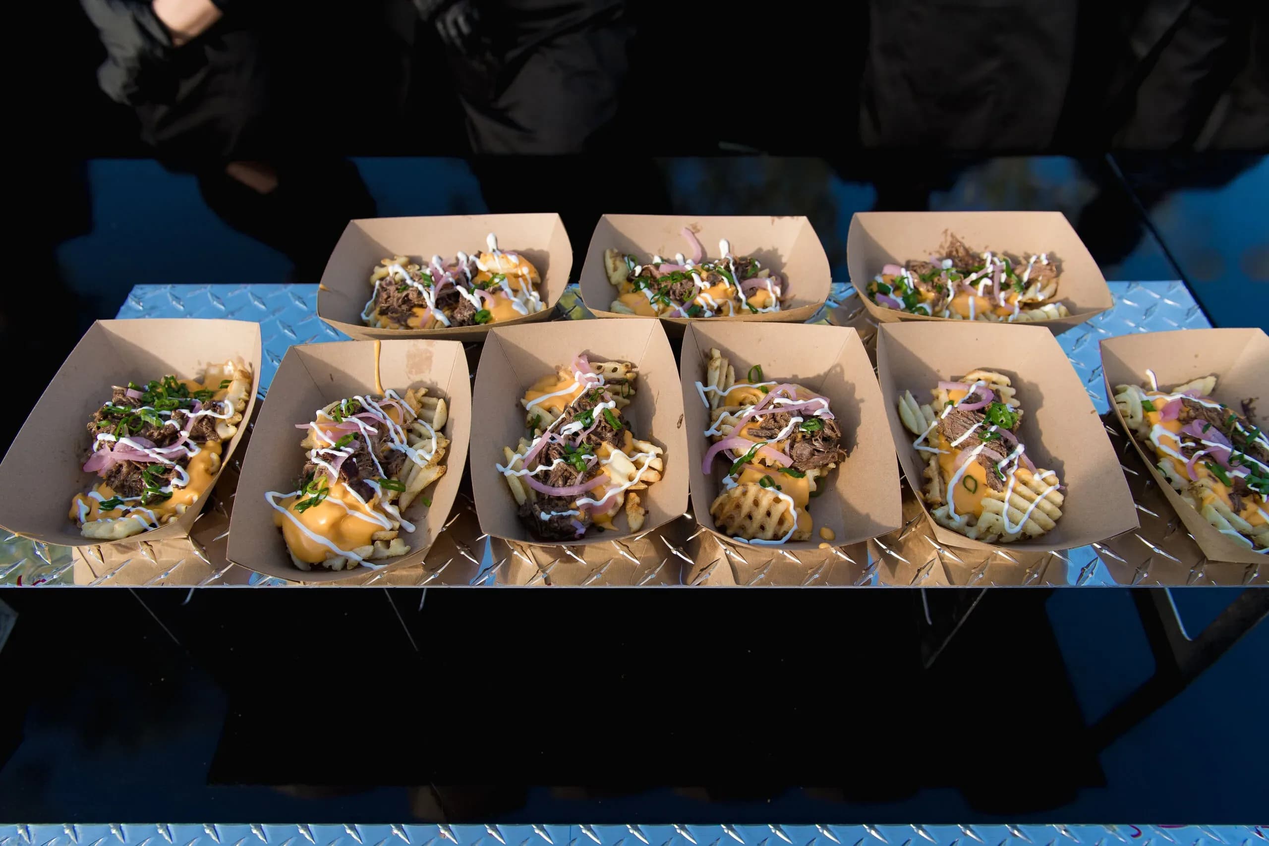 Batch of cheesy waffle fries with fresh toppings via Canyon's party event catering services